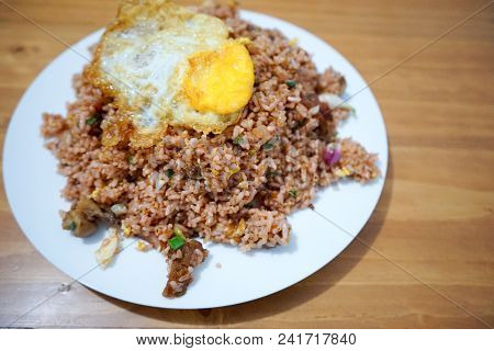 Pork Fried Rice With Spiegelei Egg On White Plate Wooden Table