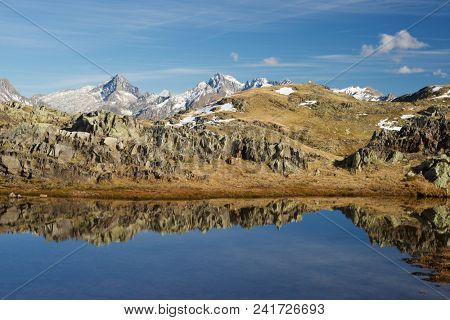 Midi Dossau Peak reflected in a lake. Ossau Valley, Pyrenees National Park, Pyrenees, France.