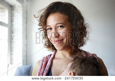 Close Up Shot Of Beautiful Positive Young Latin Female Smiling Joyfully At Camera, Satisfied With Ne