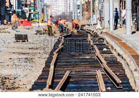 Road Workers In Uniform Laying New Railway Outdoors. Industrial Concept