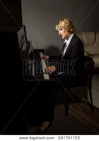 Beautiful Woman In A Business Suit Playing The Piano