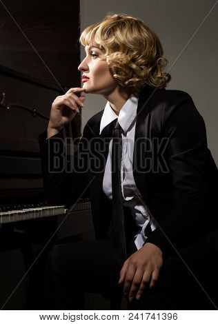 Beautiful Woman In A Business Suit Playing The Piano