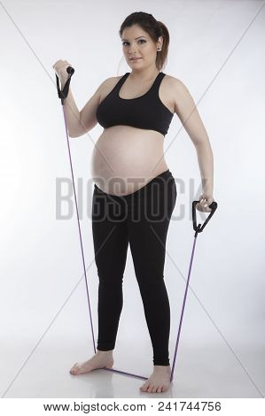 Pregnant Woman Doing Gymnastic Exercises On White Background