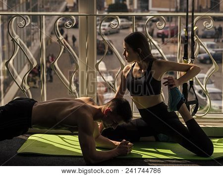 Mens Heals Body Care. Man And Woman In Sportswear In Gym, Window On Background. Couple Stretching Or