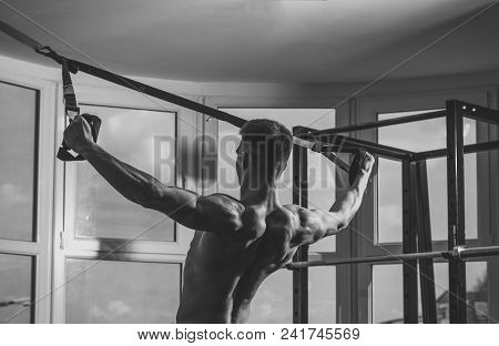 Mens Heals Body Care. Man With Torso, Sportsman, Athlete, Muscular Macho Does Exercise With Trx Loop