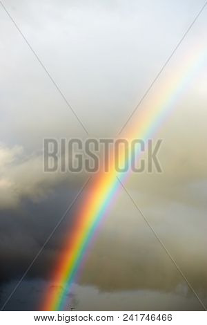 A Bright Rainbow On A Dark Stormy Sky.