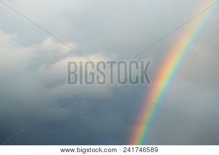 A Bright Rainbow On A Dark Stormy Sky.