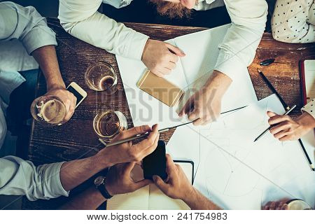 The Hands Of Young People Working And Relaxing In Pub. Team Job. Photo Businessmans Working With New