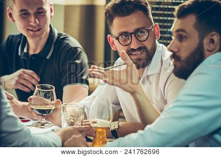 Young Cheerful People Smile And Gesture While Relaxing In Pub. Team Job. Photo Young And Mature Busi