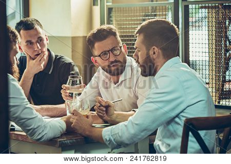 Young Cheerful People Smile And Gesture While Relaxing In Pub. Team Job. Photo Young And Mature Busi