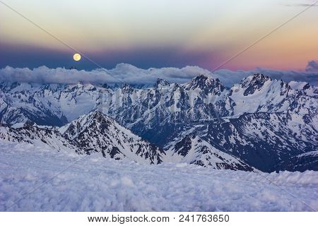 Snowy Caucasus Mountains With Glaciers At Sunset From Elbrus Slopes With Stones And Clouds On Blue S