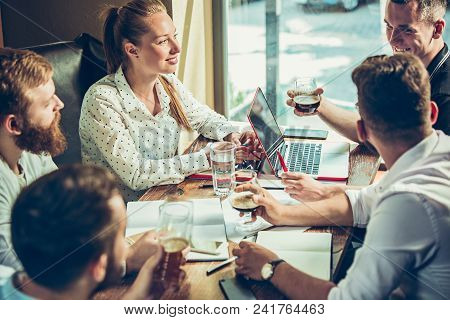 Young Cheerful People Smile And Gesture While Relaxing In Pub. Team Job. Photo Young And Mature Busi