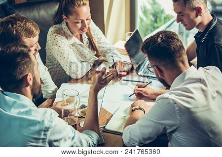 Young Cheerful People Smile And Gesture While Relaxing In Pub. Team Job. Photo Young And Mature Busi
