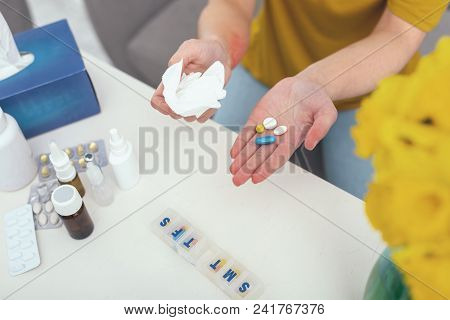 Daily Portion. Patient Leaning Over A Table Carefully Managing Their Doctors Prescription While Prep