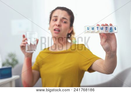 Medication Course. Young Patient Holding A Bunch Of Pills Looking Exhausted With All The Medication 
