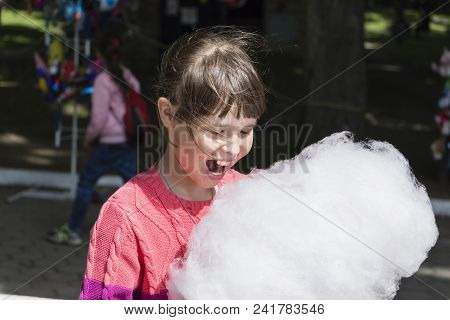 Young Girl Eating Cotton Candy In The Park