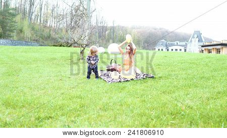 Happy Family On Picnic In Summer Park. Concept Family Relaxation. Parent And Child Go For A Walk In 