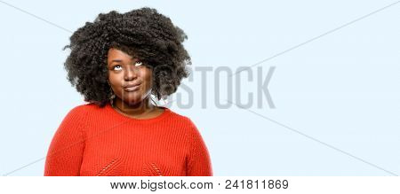 Beautiful african woman making funny face fooling, blue background