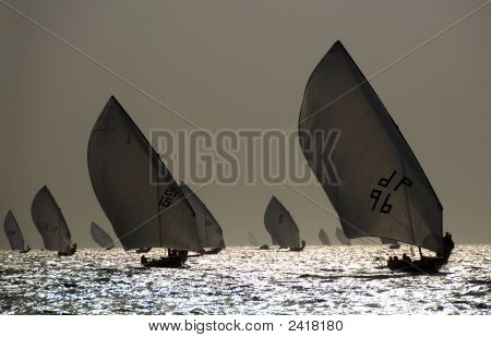 Dhows de vela contra la puesta de sol