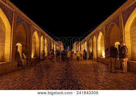 Isfahan, Iran - May 7, 2015: People Walking And Socializing On The Ancient Khaju Bridge By Night.