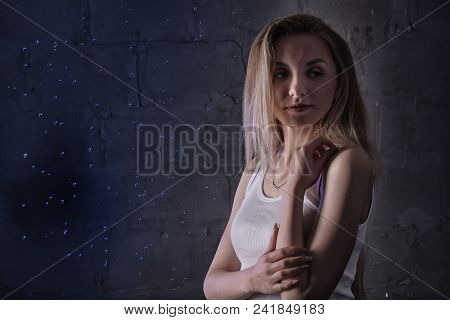 Portrain Of The Girl In The White Shirt With Water Drop In A Dark Room Illuminated By Light During A