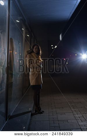 Girl Brunette Near In The Shopwindow On The Night City Street In A Cold Time