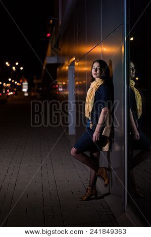Girl Brunette Near In The Shopwindow On The Night City Street In A Cold Time