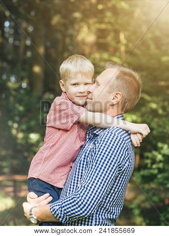 Sincere Embrace Of Father And Son In The Park. Masculinity Concept. Candid People With Real Emotion.
