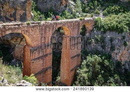 Profile Of Roman Aquaeduct With Blurred Tourists In Chelva Village, Spain