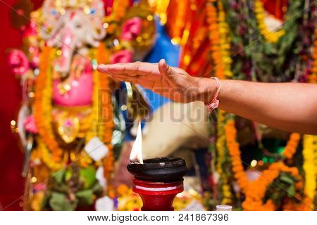 A Hand Taking Heat Of The Flame As Blessing From A Lit Clay Lamp On Top Of A Clay Stand Or Worship I