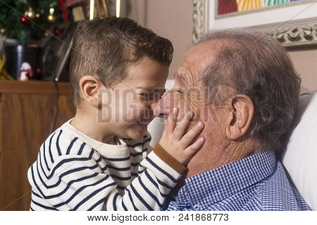 Grandfather And Grandson Playing And Smiling At Home