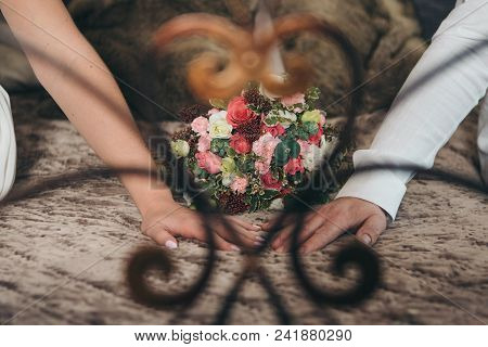 Hands Of The Bride And Groom On A Flower Background