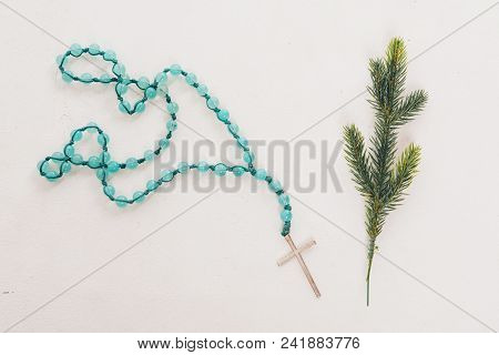 Spruce Branch And Wooden Cross On Blue Beads On White Background