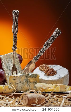 Different Types Of Cheese, Vintage Knife And Fork For Cheese And Grapes. Dark Background. Place For 