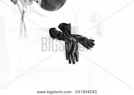 Black Leather Glovers Lying Near Transparent Vase With Roses On Vintage Female Boudoir With Console 