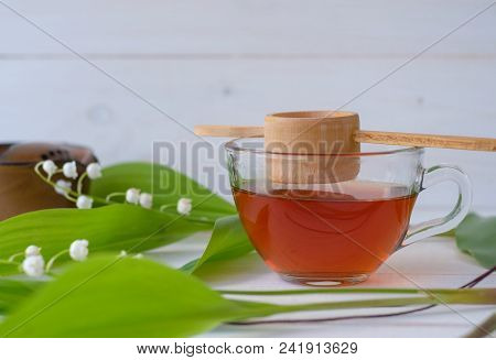 Old Chinese Tea Shen Puer In The Form Of A Nest, Brewed Tea In A Glass Cup And A Flower Of Silver Li