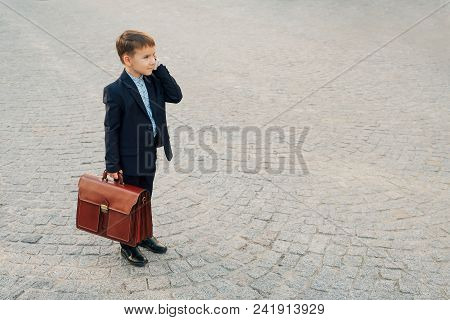 Concept Future Businessman. Side Angle Of  Smiling Businessman In Formal Wear Standing On Pedestrian