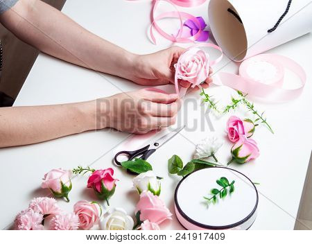 Flower Shop: A Girl Makes A Bouquet Of Roses In A Round Box. Close-up Of Hands. Horizontal Shot.