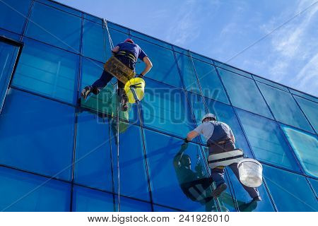 Industrial Climbers Are Applying Silicone On Joints Between Windows