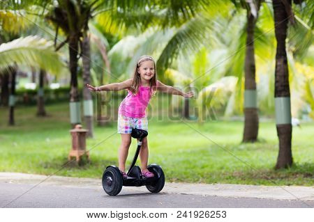 Child On Hover Board. Kids Riding Scooter In Summer Park. Balance Board For Children. Electric Self 