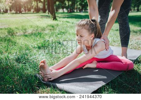 A Picture Of Small Girl Stratching. Adud Woman Is Helping Her To Do That Right. Girl Is Keeping Her 