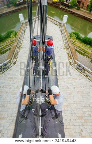 Industrial Climbers Are Applying Silicone On Joints Between Windows