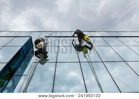 Industrial Climbers Are Applying Silicone On Joints Between Windows
