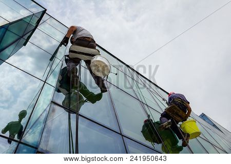 Industrial Climbers Are Applying Silicone On Joints Between Windows