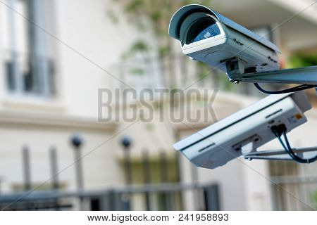 Focus On Security Cctv Camera Or Surveillance System With Private Builiding On Blurry Background