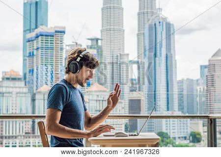 Young Man Teaches A Foreign Language Or Learns A Foreign Language On The Internet On Her Balcony Aga