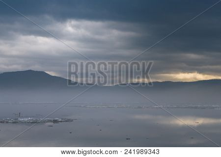 Duck Floating On The River Against The Glow Coming Out Of The Mountains