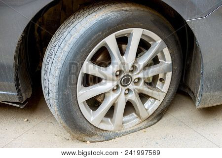 Car Wheel Flat Tire On The Road. Road Accident.