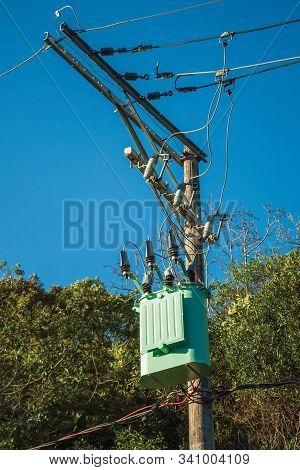 Detail Of High-voltage Power Pole Transformer With Electrical Wiring In Front Of Trees Near Gramado.