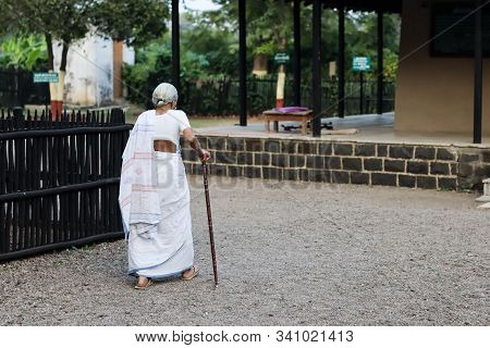 November 30, Maharashtra India, - An Elderly Lady With Walking Stick In White Dress Walking At Gandh